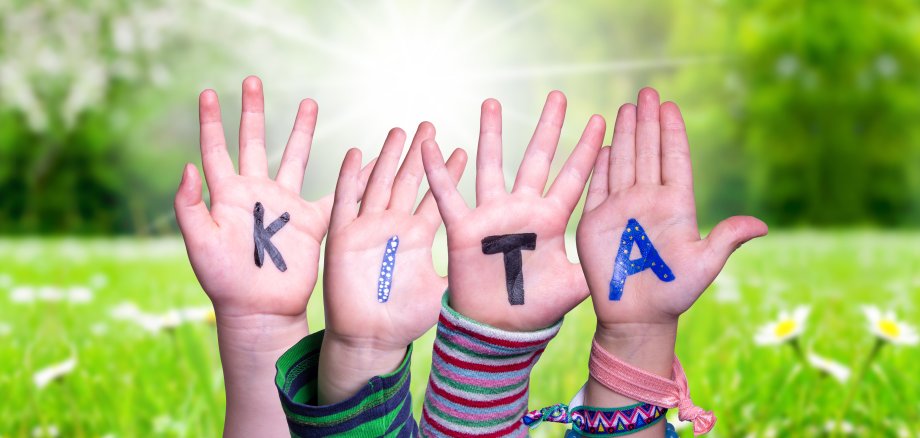 Children Hands Building Word KITA Means Kindergarden, Grass Meadow